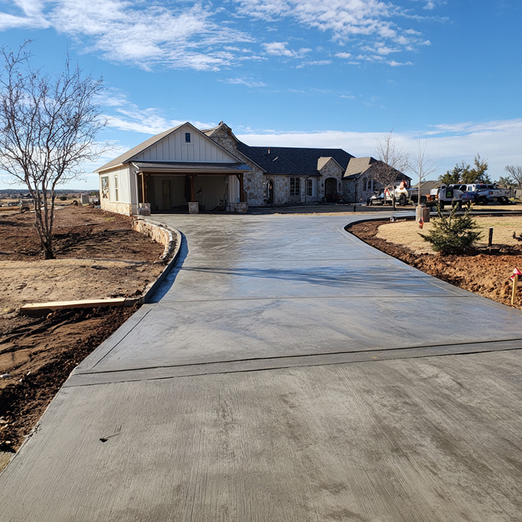 a concrete driveway with new concrete, the front of the house in the background in Abilene TX