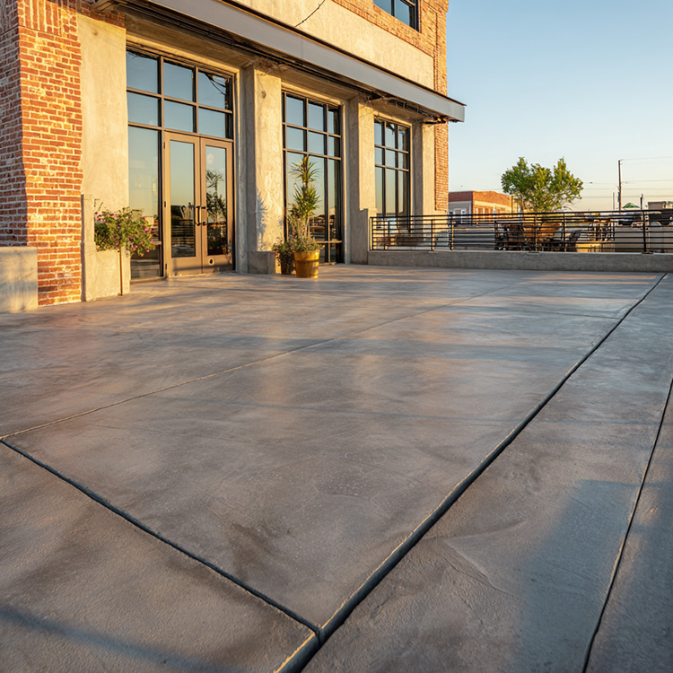 A freshly finished concrete patio outside a commercial building in Abilene, Texas